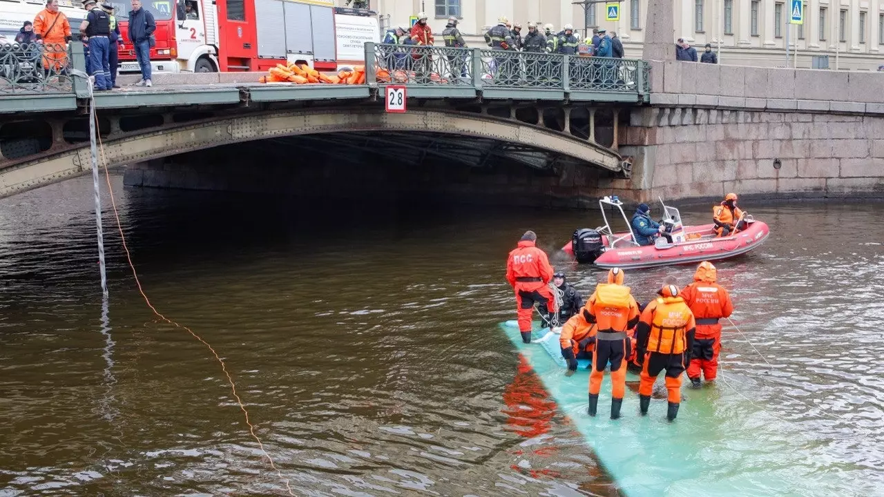 Спасатели стоят на крыше утонувшего в Мойке автобуса.