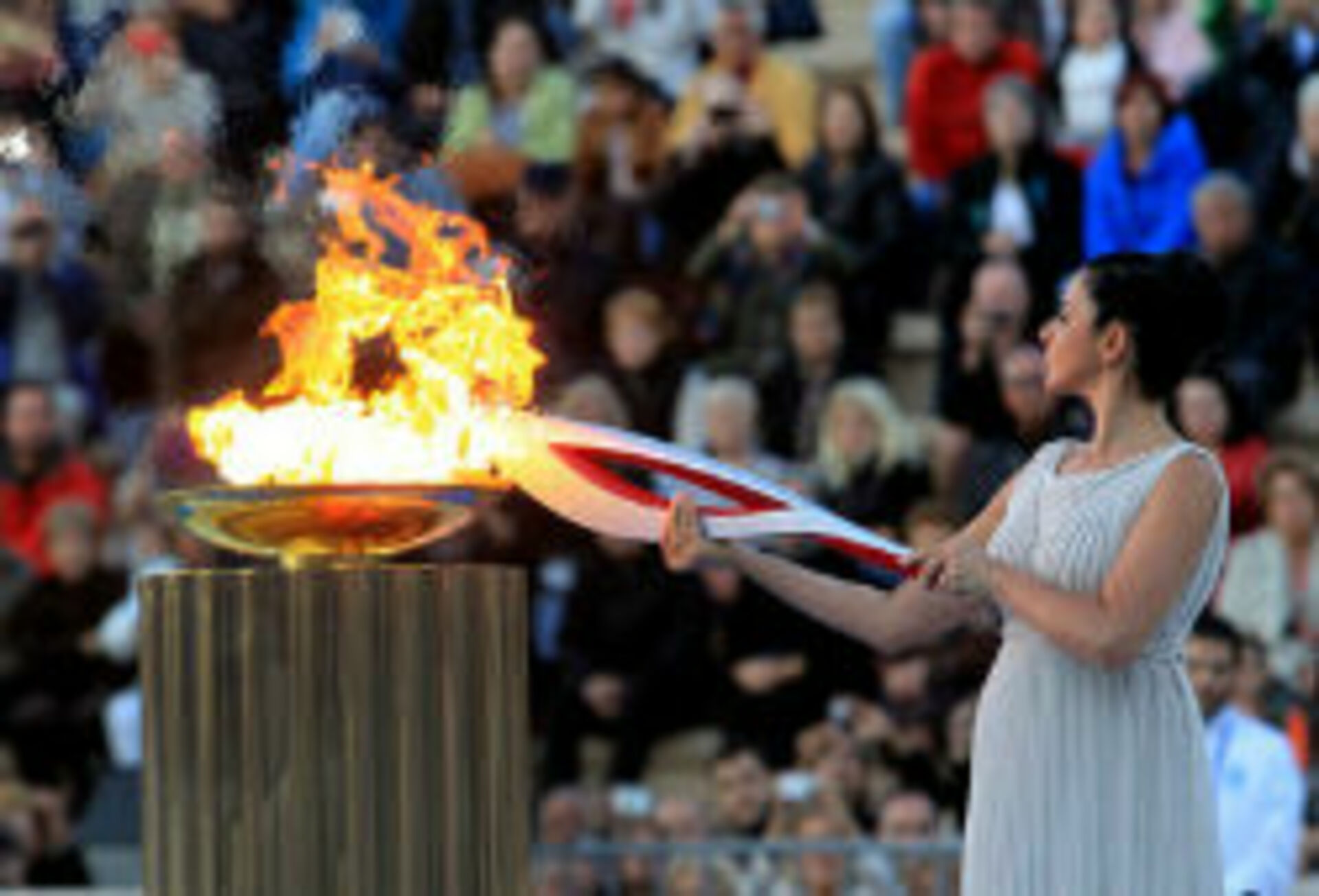 Олимпийский огонь современных игр зажигается. Факел эстафеты олимпийского огня. Зажжение олимпийского огня. Олимпийский огонь 2014. Церемония зажжения олимпийского огня.