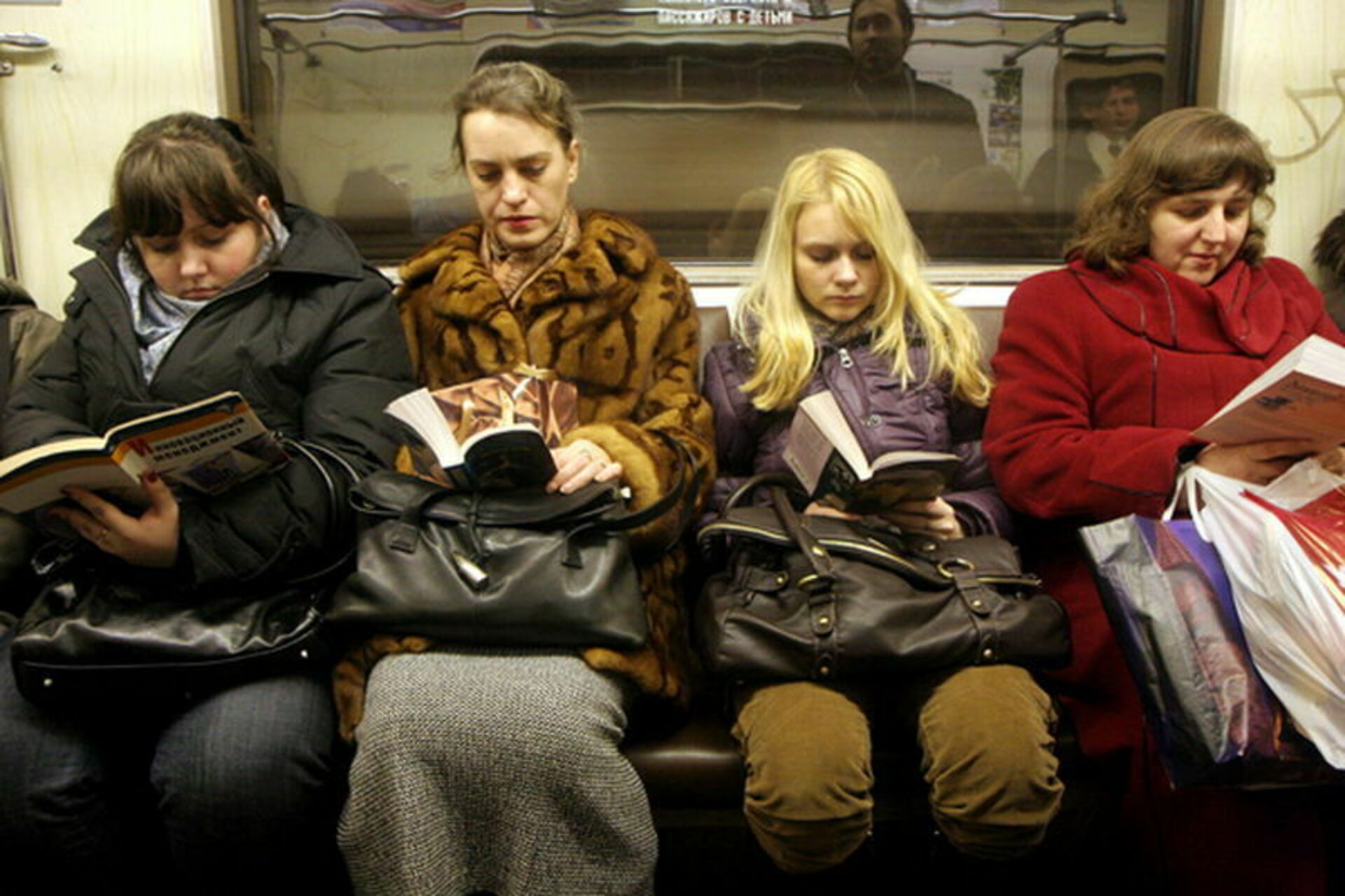 Картинки страна читает. Чтение в метро. Люди с книгами в метро. Люди читают в метро. Книга для чтения в метро.
