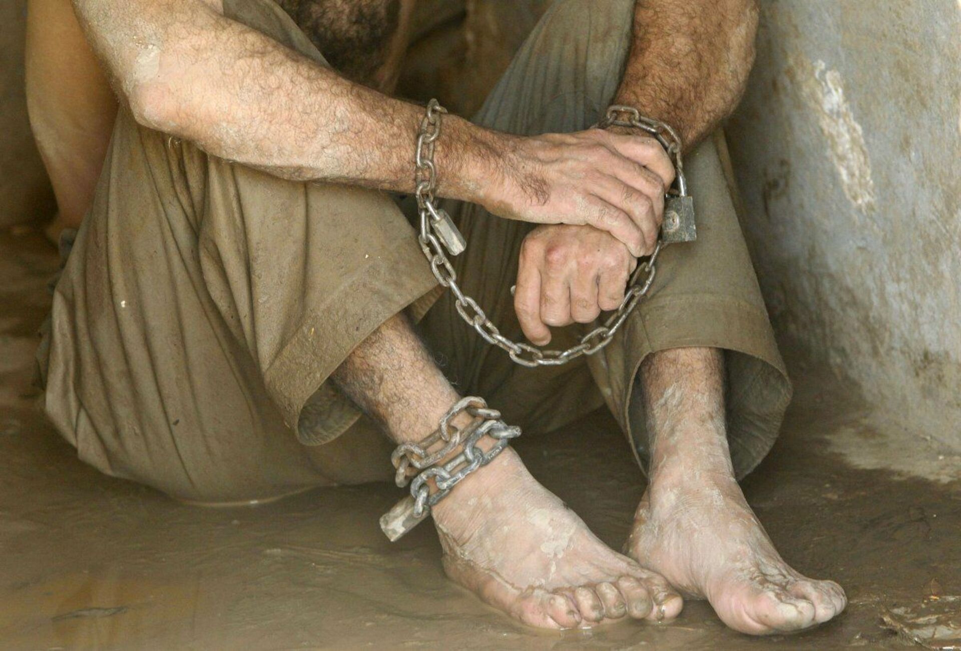 Эксплуатация торговли людей. Человек в кандалах. Рабство. Кандалы на ногах. Трудовое рабство.