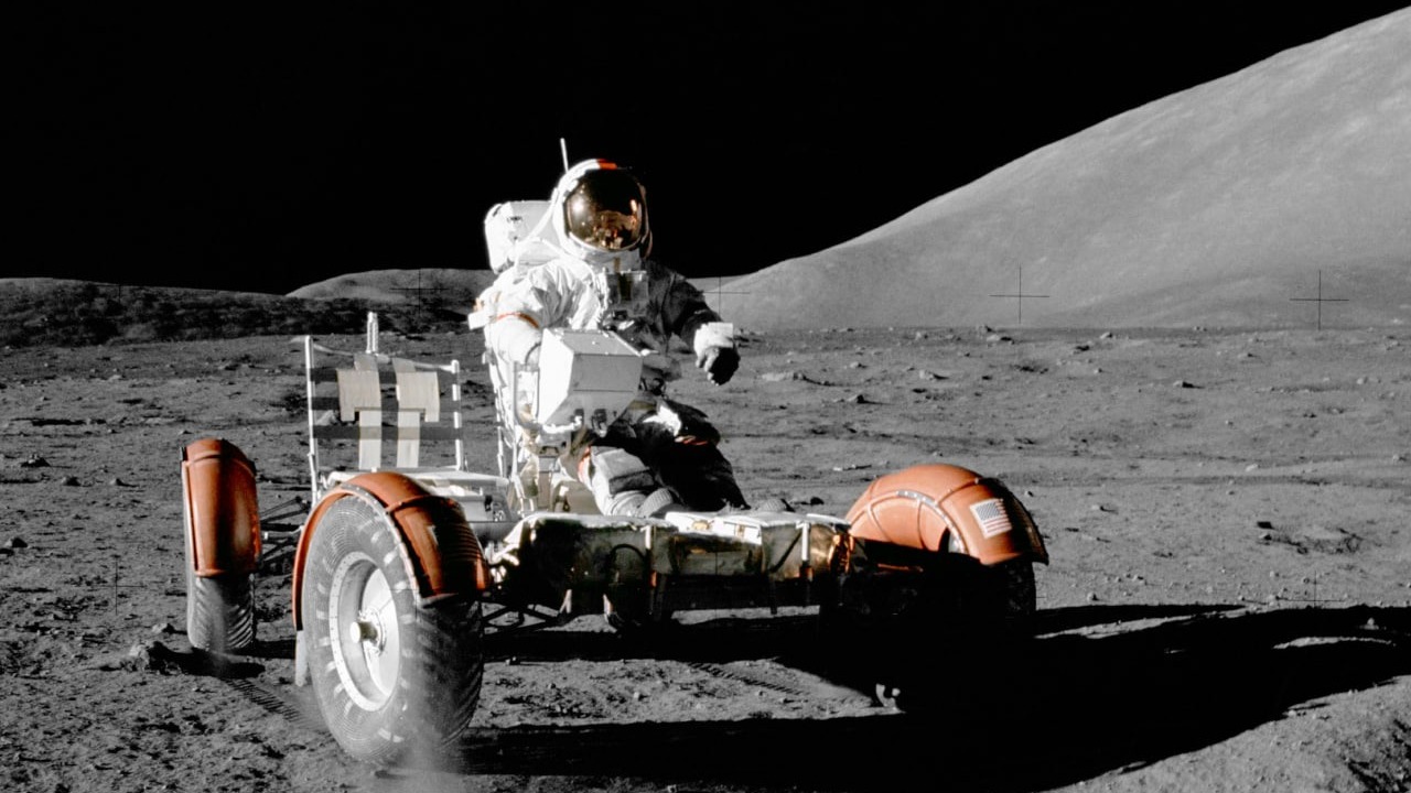 Член последнего лунного экипажа "Аполлон-17" едет по поверхности Луна на ровере в 1972 году 