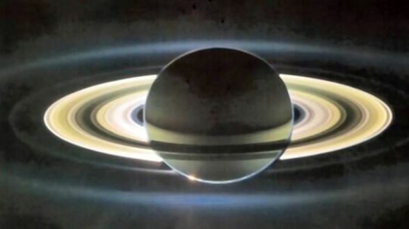 Снимок диска плотных колец Сатурна радиусом более 200 тыс. км. Внизу видна точка солнечного света. Солнце находится за Сатурном на расстоянии 1,2 млрд. км. Прозрачность колец подтверждает, что кольца состоят из космического водяного льда.  