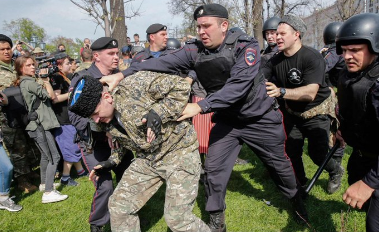 Задержание человека в казачьей форме в Москве. Сегодня некоторые из них участвовали в нападениях на протестующих.