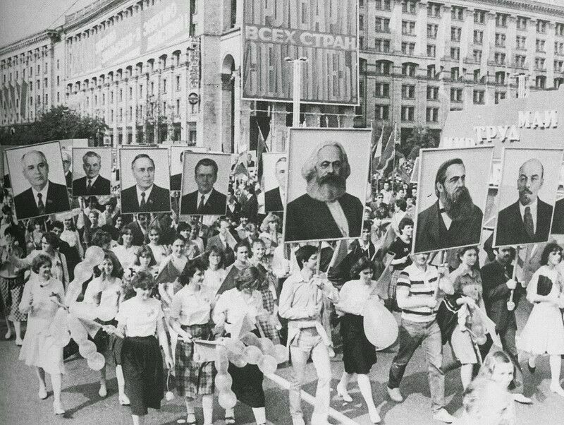 Люди несут портреты партийных чиновников и основателей "Марксизма-Ленинизма":
