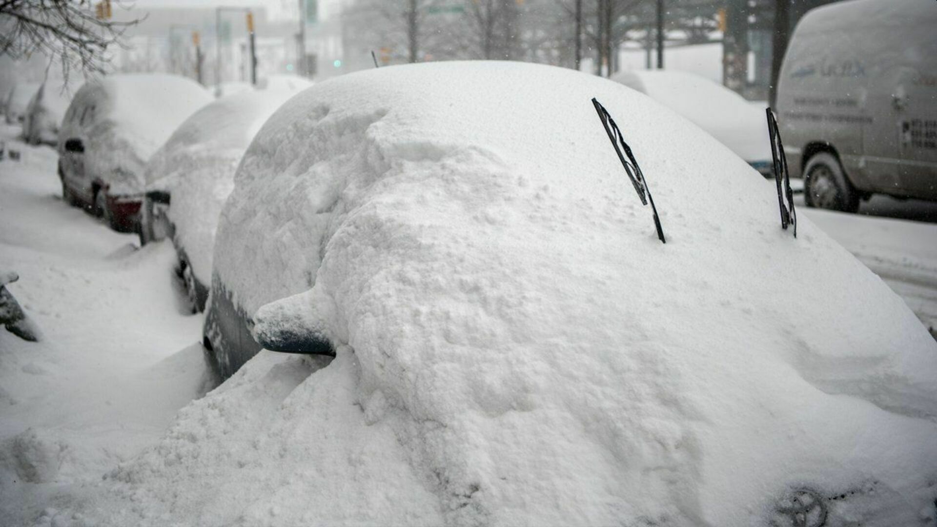 Очень большие сугробы. Много снега. Машина в сугробе. Машину засыпало снегом. Откапывает машину.