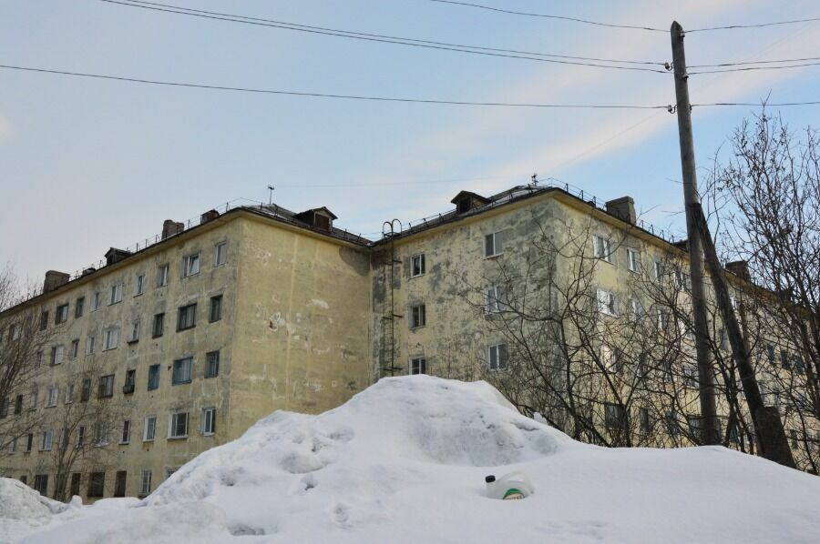Типичный пейзаж Мурманска - горы снега и облезлые дома 