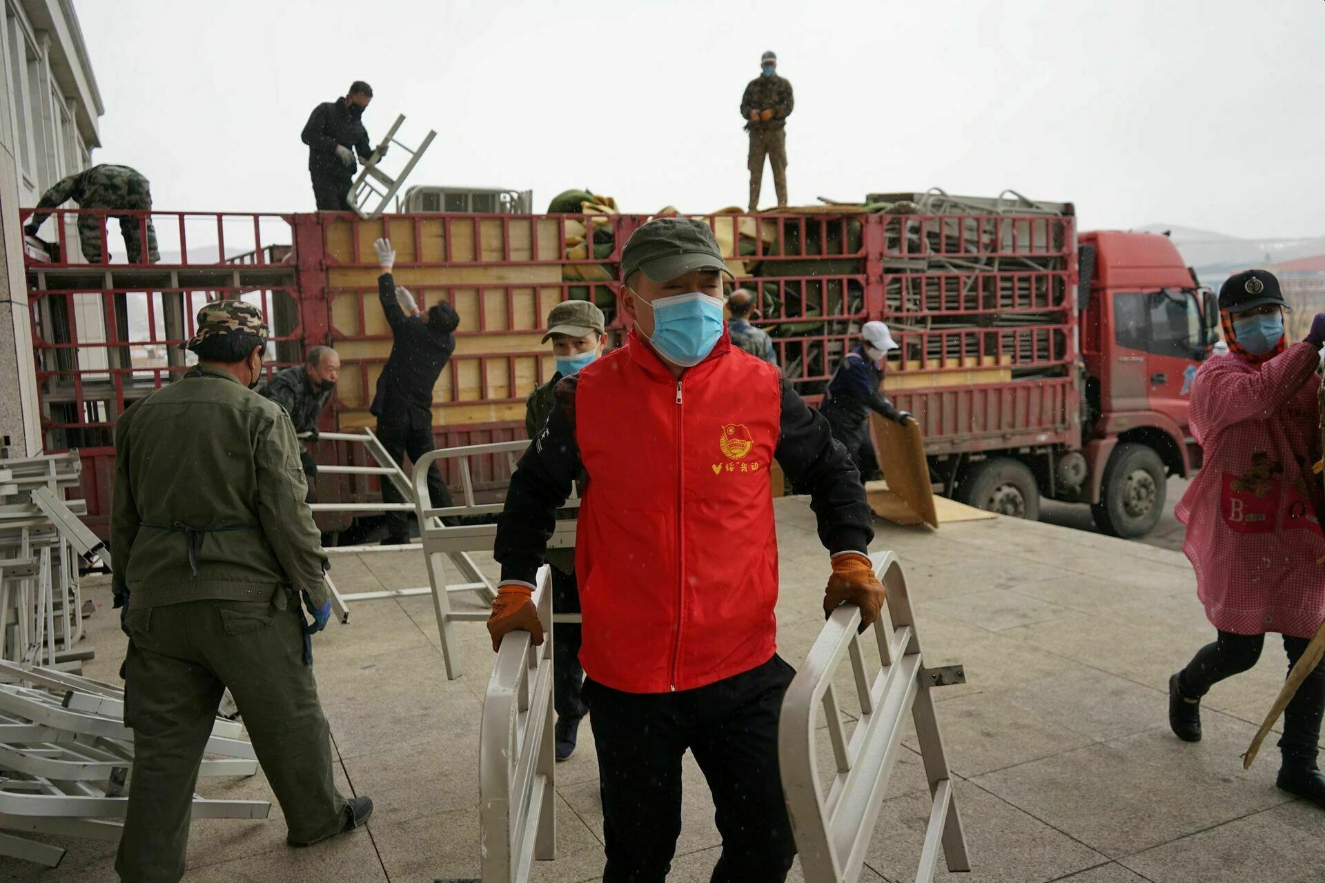 Фотография, опубликованная в газете China Daily: рабочие разгружают каркасы